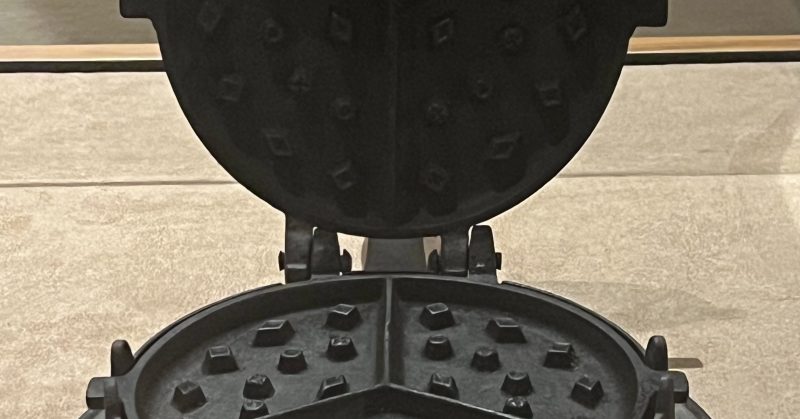 Waffle irons and their bases - A cast iron waffle maker in the Blackhawk Museum.